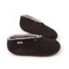 BOOTIE black white-a A pair of felted wool booties black with white interior for indoors use. They feature a leather tag on the side of the right shoe and tie elastic laces.