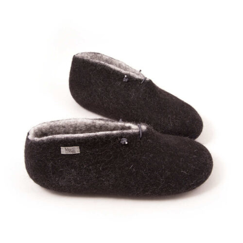 A pair of felted wool booties black with white interior for indoors use. They feature a leather tag on the side of the right shoe and tie elastic laces.
