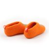 Kids slipper shoes seen sideways at the back. They are made from a continous wool felt fabric in orange with a turquoise decorative star at the front part.
