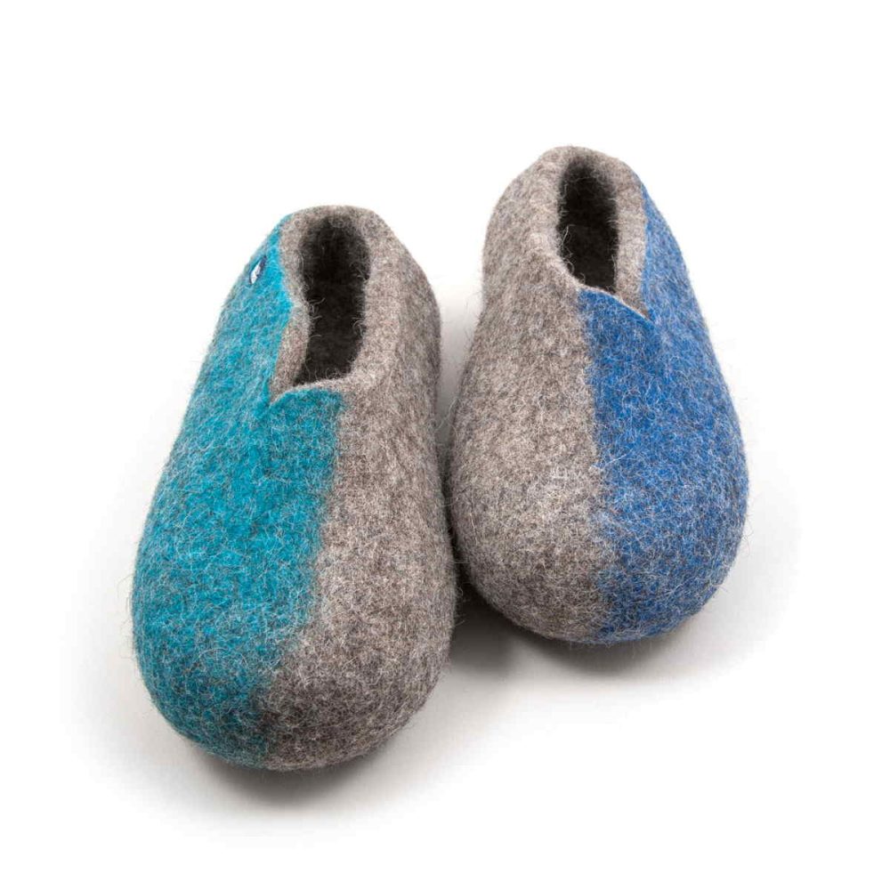 A pair from the SEASONS wool slippers collection by Wooppers. The shoes are felted in grey wool with a stylish cut at the opening and different colors on the side of each shoe - turquoise for the right and blue for the left side. The slippers are photographed from the front side.