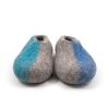 Pure wool slippers from the SEASONS collection by Wooppers. The shoes are felted in grey wool with a stylish cut at the opening and different colors on the side of each shoe - turquoise for the right and blue for the left side. The slippers are photographed from the front side.