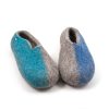 A pair ofslippers from the SEASONS collection by Wooppers. The shoes are felted in grey wool with a stylish cut at the opening and different colors on the side of each shoe - turquoise for the right and blue for the left side. The slippers are photographed from the front side.
