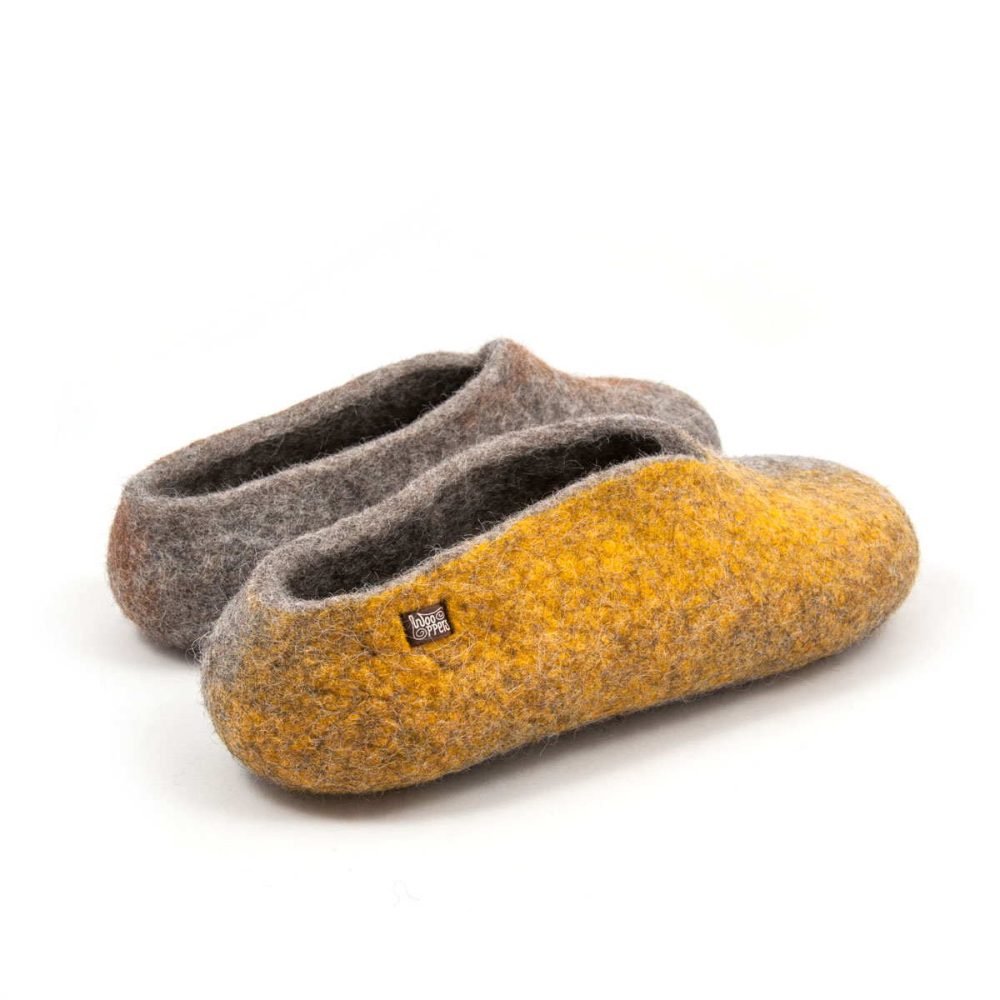 Wool slippers from the SEASONS collection by Wooppers. The shoes are felted in grey wool with a stylish cut at the opening and different colors on the side of each shoe - yellow for the right and brown for the left. The slippers are photographed from the right back side.