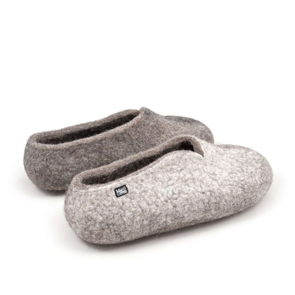 Winter - Wool slippers from the SEASONS collection by Wooppers. The shoes are felted in grey wool with a stylish cut at the opening and different colors on the side of each shoe - white for the right and black for the left. The slippers are photographed from the right back side.