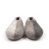 Winter - wool slippers from the SEASONS collection by Wooppers. The shoes are felted in grey wool with a stylish cut at the opening and different colors on the side of each shoe - white for the right and black for the left. The slippers are photographed with the right shoe over the left one.