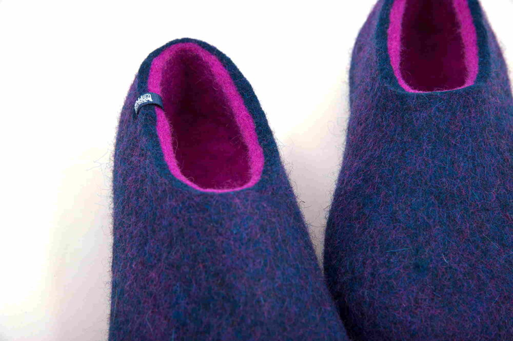 Blue wool slippers with fuchsia interior detail.