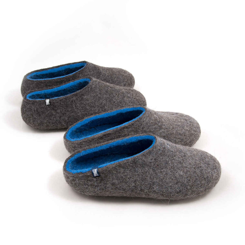 Two pairs of wool house slippers Grey and Blue. The pair at the front with a low cut at the back and the pair at the back of felt wool slippers by Wooppers seen from the top.