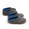 Two pairs of wool house slippers Grey and Blue. The pair at the front with a low cut at the back and the pair at the back of felt wool slippers by Wooppers seen from the top.
