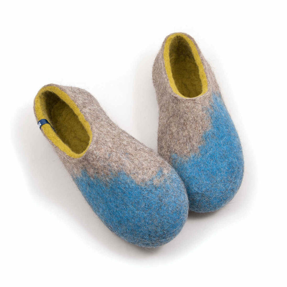 AMIGOS blue natural lime felt wool slippers by Wooppers -g Seen from the front - A pair of house shoes for women made of felt wool (slip-on, closed-back, low-cut ankle) mottled grey with bright blue in the area of the toes and lime green on the inside. The whole shoe is one continuous piece of felt - no stitches. Right shoe slightly overlaps the left.