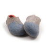 AMIGOS stone blue natural orange -d Seen from the front - A pair of wool felt slippers (slip-on, closed-back, low-cut ankle) mottled grey with pale blue in the area of the toes and burned orange on the inside. The whole shoe is one continuous piece of felt - no stitches.