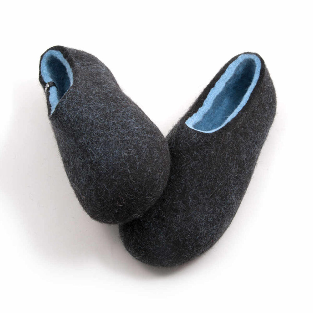 A pair of black comfortable slipper shoes with light blue on the inside. Mad3e of wool. Seen from a front elevated view..