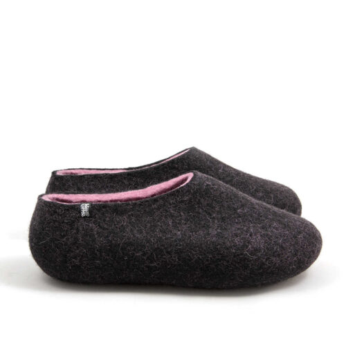 A pair of wool house slippers with pink on the inside. Side view.