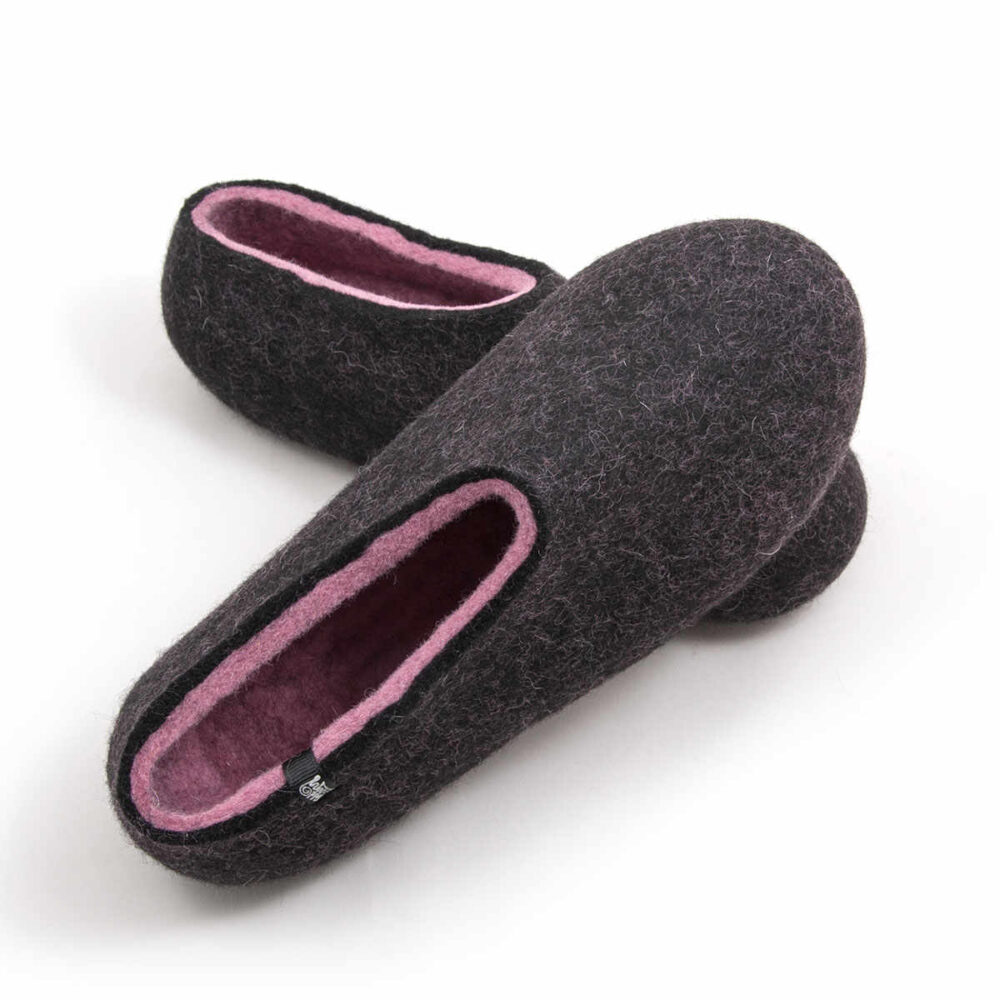 DUAL black pink_f A pair of wool house slipper shoes with pink on the inside. One shoe is rested upon the other..